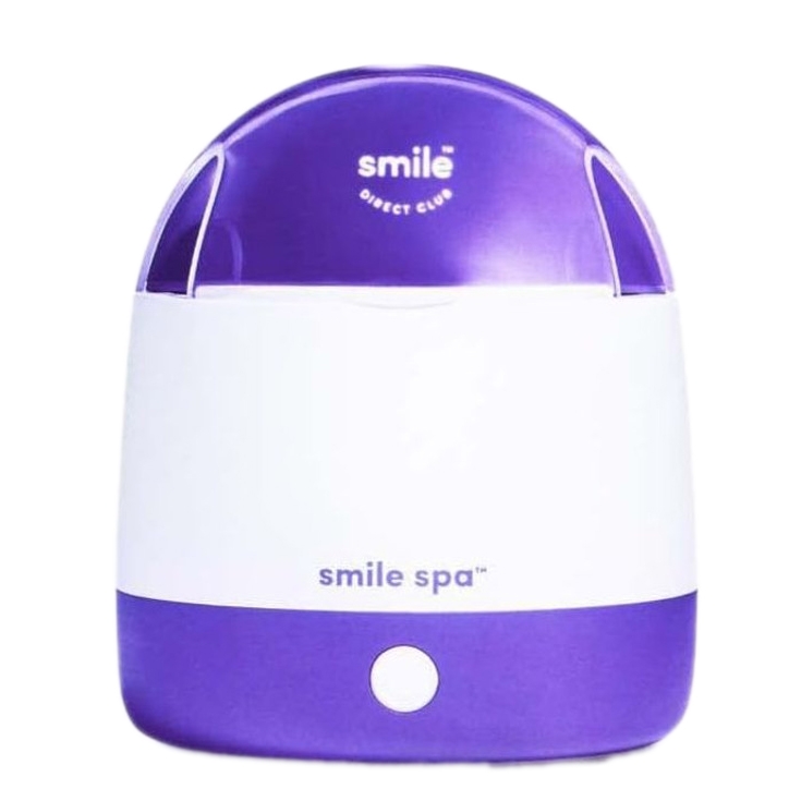 A purple and white \“smile spa\“ device, likely used for cleaning dental appliances, with \“Smile Direct Club\“ branding.