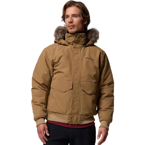 A man is wearing a brown winter jacket with a fur-lined hood. The jacket has a Columbia logo on the chest and features large front pockets and ribbed cuffs.