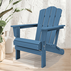 A blue Adirondack chair with a classic slatted design is shown against a textured wall, accompanied by a plant in a woven basket and a white vase in the background.