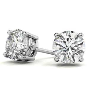 A pair of round-cut lab-grown diamond studs set in a four-prong silver metal mount.
