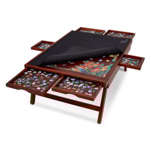 A wooden puzzle table with a central puzzle area, covered partially by a black mat, and six side drawers holding puzzle pieces.