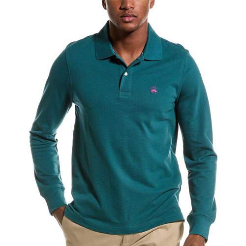 A man is wearing a long-sleeved, green polo shirt with a small pink logo on the chest.