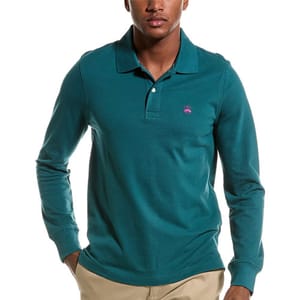 A man is wearing a long-sleeved, green polo shirt with a small pink logo on the chest.