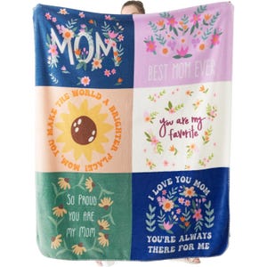 A colorful patchwork blanket featuring floral designs and heartwarming messages for Mom, such as \“Best Mom Ever,\“ \“You are my favorite,\“ and \“I love you Mom.\“