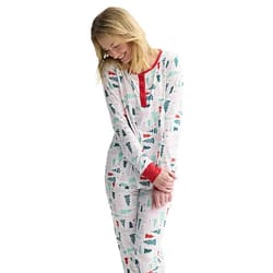 Woman wearing a festive pajama set with a Christmas tree pattern, featuring red cuffs and neckline.