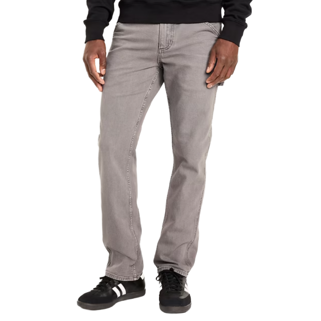 A person is wearing gray straight-leg jeans paired with black sneakers featuring white stripes.