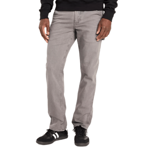 A person is wearing gray straight-leg jeans paired with black sneakers featuring white stripes.