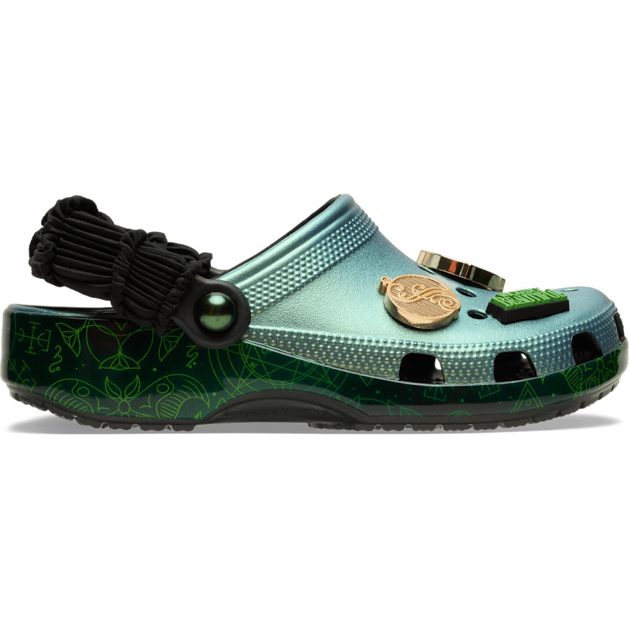 A pair of Crocs with a metallic teal and green gradient design, featuring esoteric symbols, black paracord heel strap, and several decorative charms.