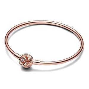 A rose gold bracelet featuring a minimalist design with a small knot-like detail, adorned with a single clear gemstone.