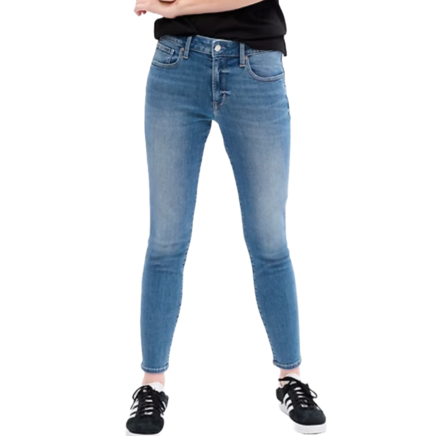 Blue mid-rise legging jeans with a slightly faded finish, featuring front and back pockets. Paired with black sneakers and a black top.