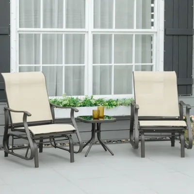 Two beige outdoor glider chairs with armrests are positioned around a small round black glass table, set on a gray patio in front of a window with a flower box.