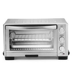 A compact stainless steel toaster oven with adjustable temperature, function, and timer dials, featuring a glass door and a wire rack inside.