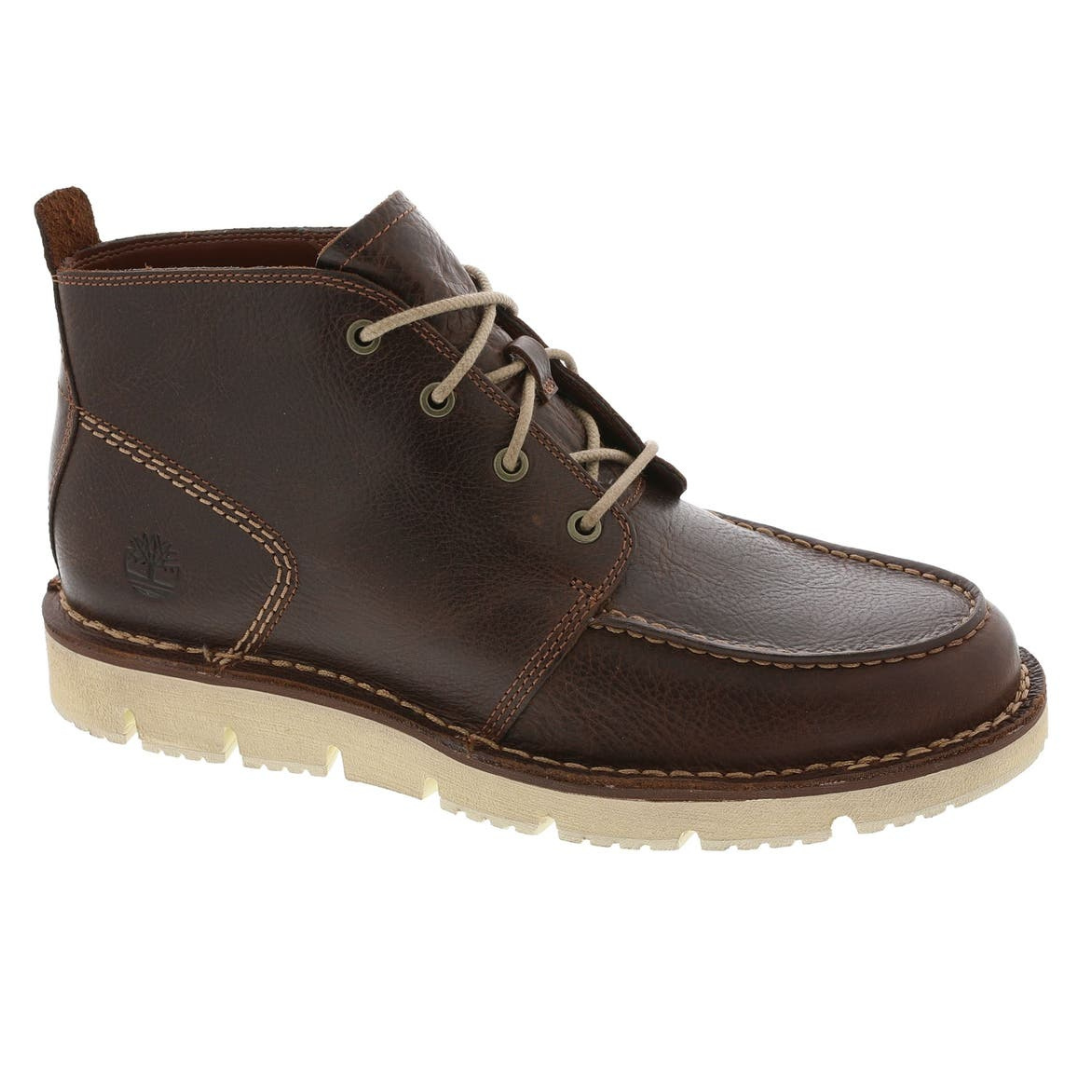 A brown leather chukka boot with a moc toe design, featuring contrast stitching and a white rubber sole.