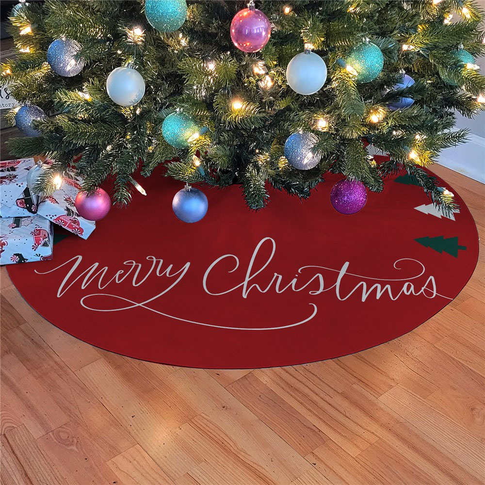 Christmas tree skirt with \“Merry Christmas\“ text, set under a decorated tree with baubles and lights. Presents with festive wrapping are placed nearby.