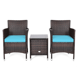 A patio set featuring two wicker chairs with turquoise cushions and a matching wicker side table, all with metal-capped legs for stability.
