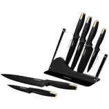 A set of black kitchen knives with gold accents in a clear stand, featuring various sizes and types including serrated and straight-edged blades.