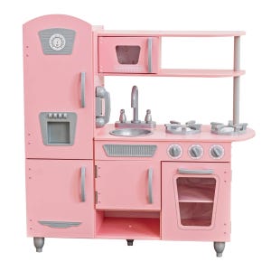 Pink toy kitchen set with fridge, microwave, sink, stove, and oven featuring silver handles and knobs.