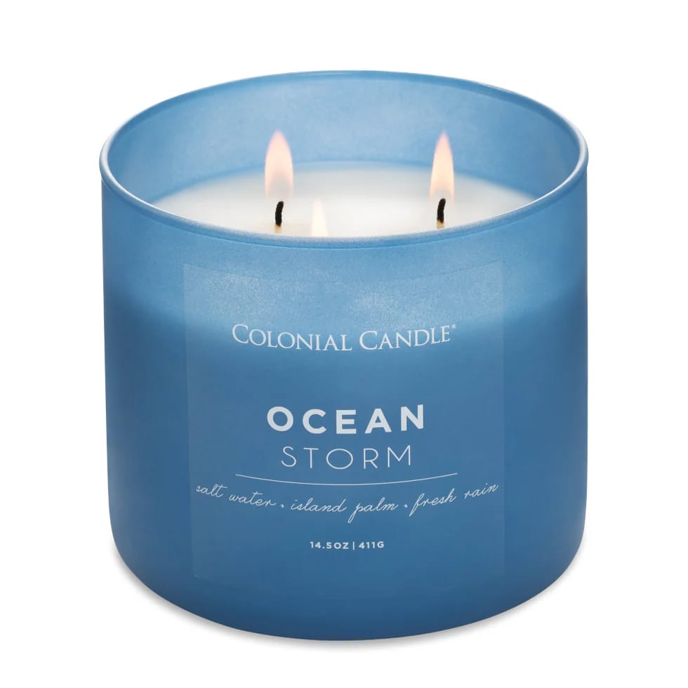 Blue Colonial Candle labeled \“Ocean Storm,\“ featuring scents of salt water, island palm, and fresh rain, with three wicks.