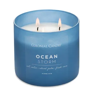 Blue Colonial Candle labeled \“Ocean Storm,\“ featuring scents of salt water, island palm, and fresh rain, with three wicks.