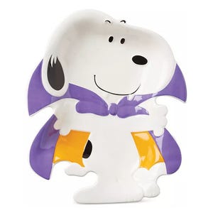 Ceramic dish shaped like a cartoon dog in a purple cape, holding yellow trick-or-treat bags.