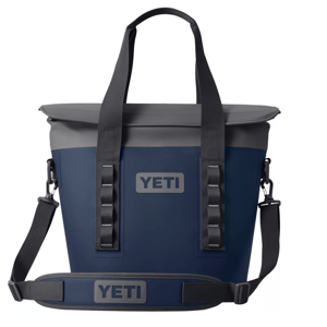YETI soft-sided cooler with a navy and gray color scheme, featuring dual handles and an adjustable shoulder strap for easy carrying.