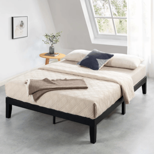 A minimalist bedroom setup features a modern bed with a black frame and beige bedding, complemented by a side table with a vase of greenery.