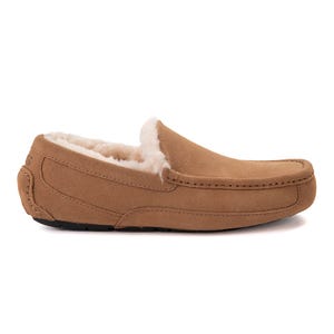 A tan suede moccasin-style slipper lined with plush fur, featuring a rubber sole for indoor and outdoor use.