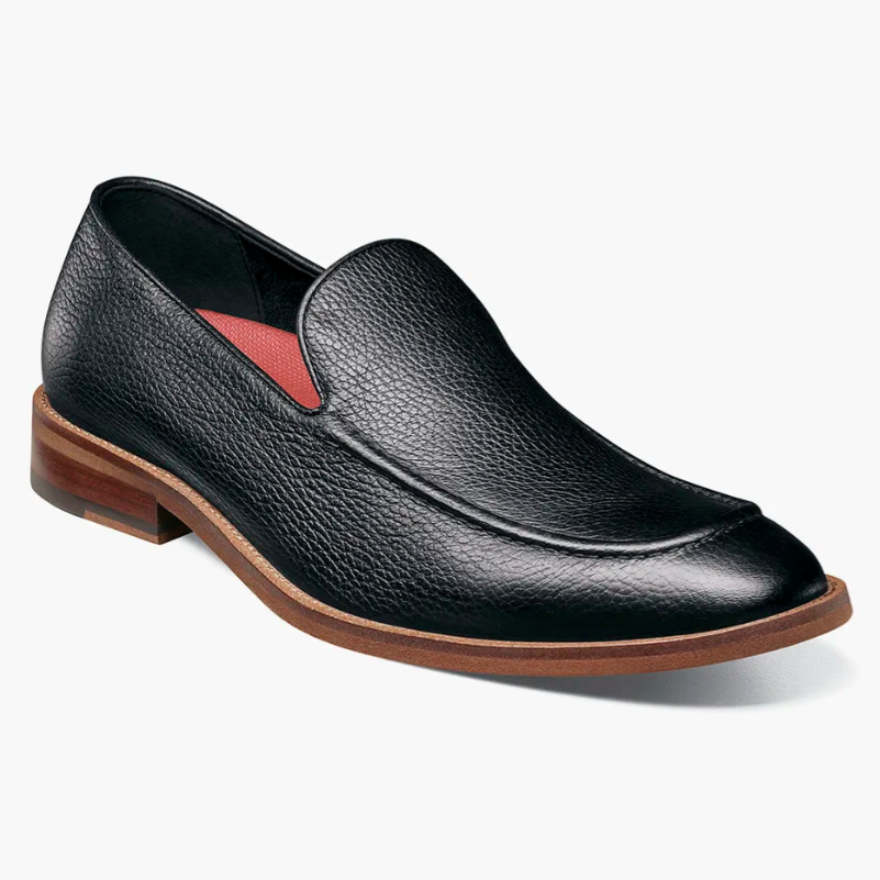 A black leather slip-on shoe with a textured finish features a brown sole and a red interior lining.