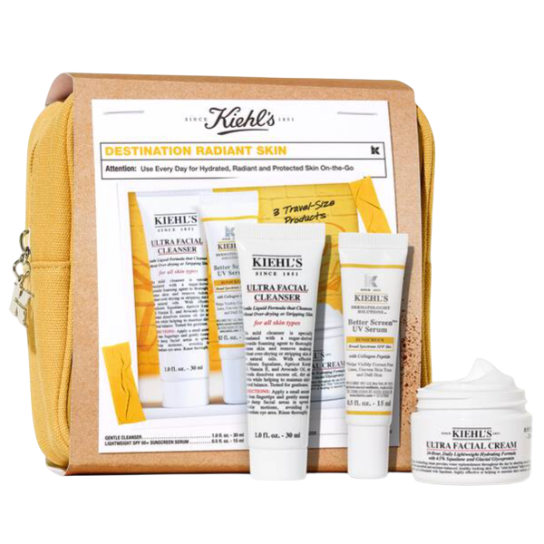 Kiehl's Destination Radiant Skin kit includes three travel-size products: Ultra Facial Cleanser, Better Screen UV Serum, and Ultra Facial Cream, all packaged in a yellow pouch.