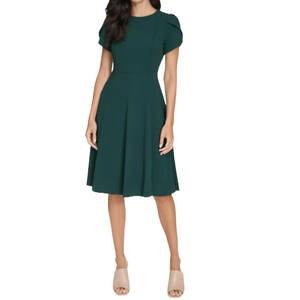 A knee-length, forest green dress with short sleeves, a fitted waist, and a flared skirt, paired with beige open-toe heels.