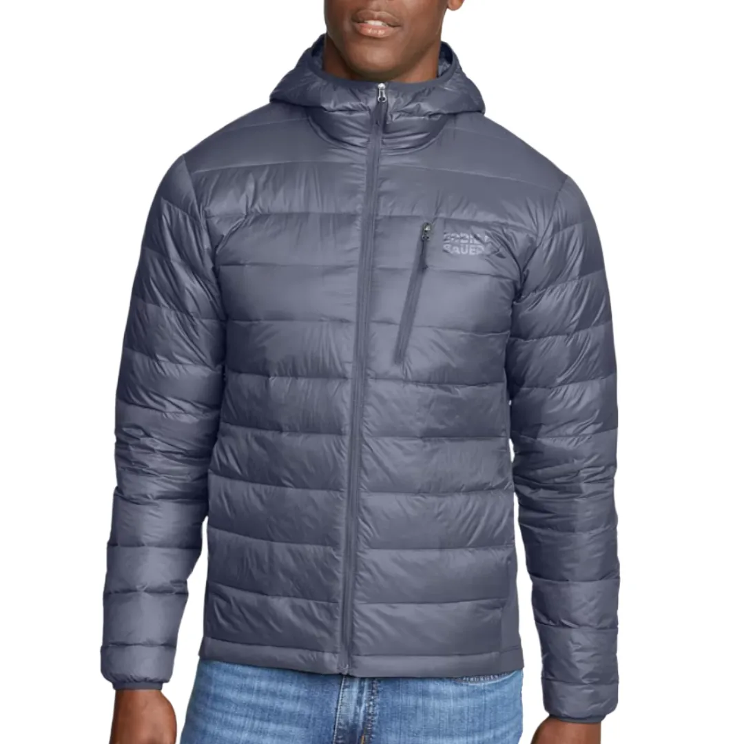 A gray hooded puffer jacket with a front zipper, chest zip pocket, and horizontal quilting, worn with blue jeans.