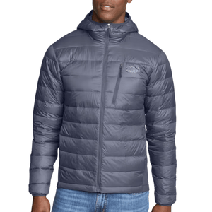 A gray hooded puffer jacket with a front zipper, chest zip pocket, and horizontal quilting, worn with blue jeans.