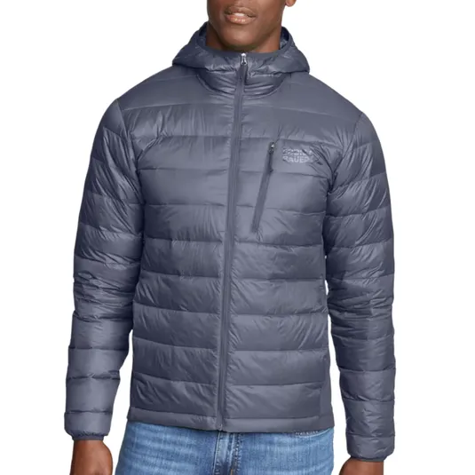 A gray hooded puffer jacket with a front zipper, chest zip pocket, and horizontal quilting, worn with blue jeans.