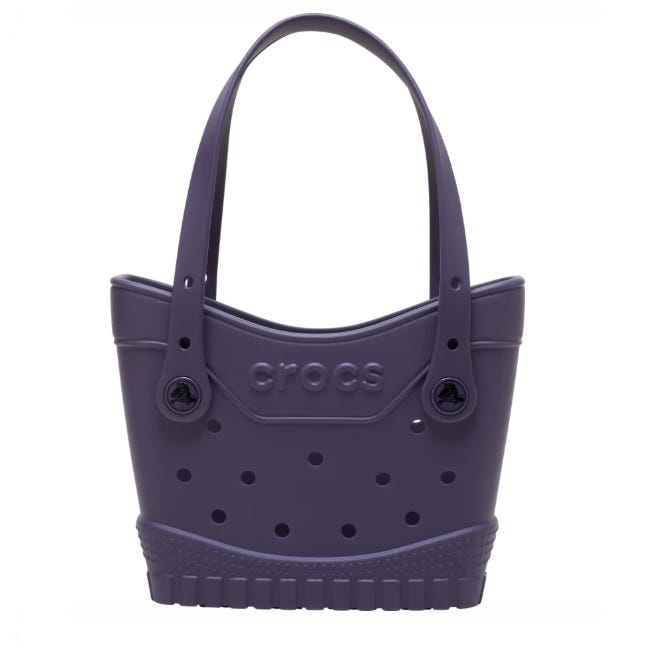Purple Crocs tote bag with perforated design and dual handles, featuring the Crocs logo.
