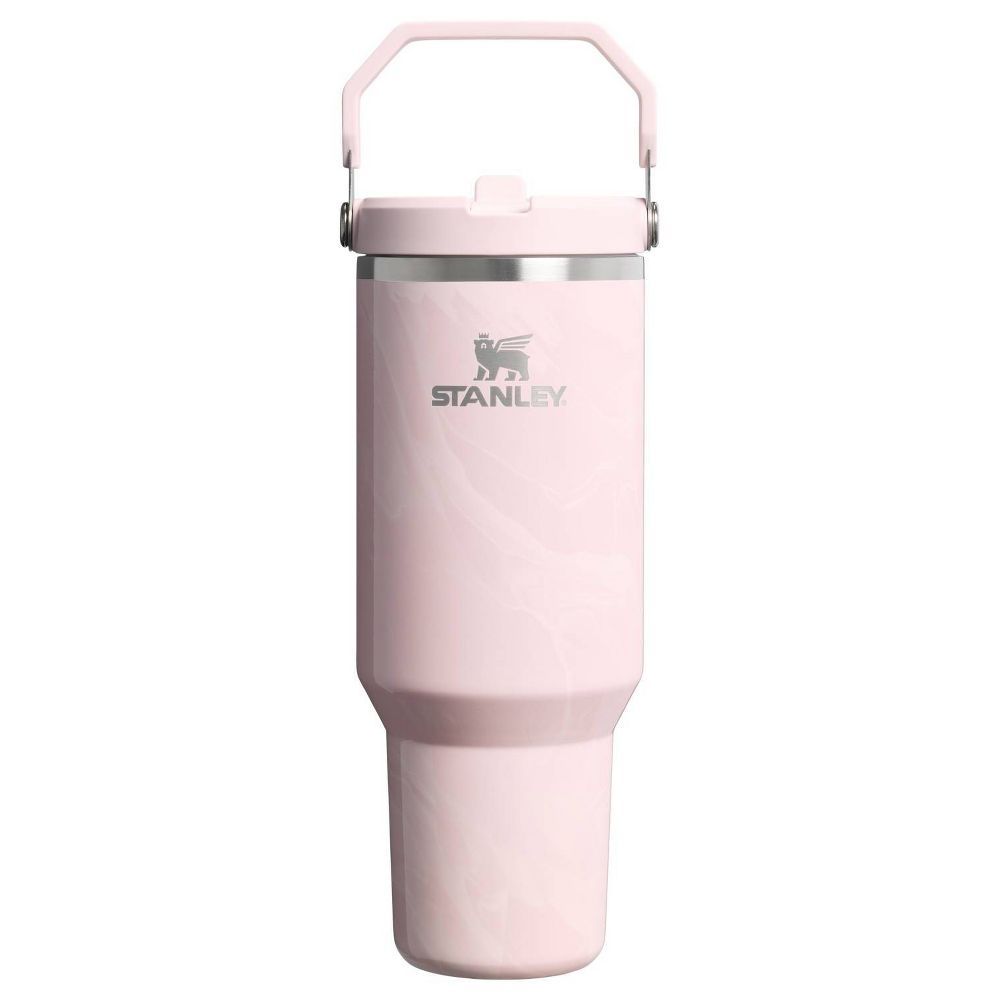 A pink Stanley tumbler with a handle, designed for portability and efficient beverage storage.