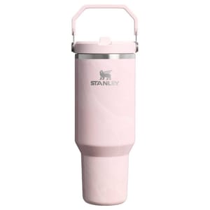 A pink Stanley tumbler with a handle, designed for portability and efficient beverage storage.