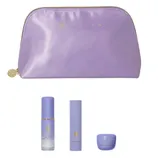 A lavender Tatcha pouch contains three skincare items: Luminous Dewy Skin Mist, The Serum Stick, and The Dewy Skin Cream, all in matching purple packaging.