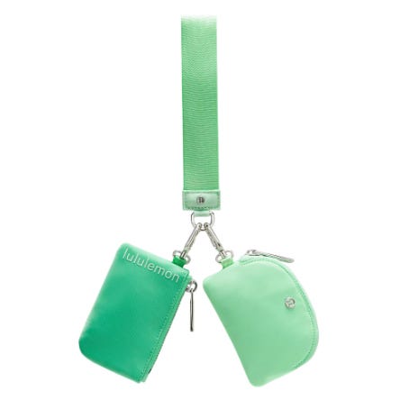 A mint green keychain set with a wrist strap features two zippered pouches attached by metal clasps, one with a \“lululemon\“ logo.