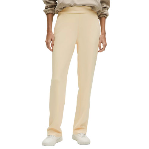 A person is wearing light beige straight-leg pants paired with a beige sweatshirt and white sneakers.