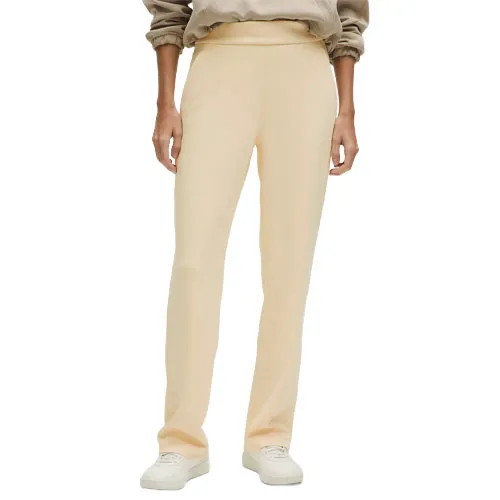 A person is wearing light beige straight-leg pants paired with a beige sweatshirt and white sneakers.
