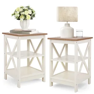 Two small side tables with a white frame and a wood top, featuring X-shaped side braces. One table holds a lamp and a glass of water, the other a vase of flowers and books.