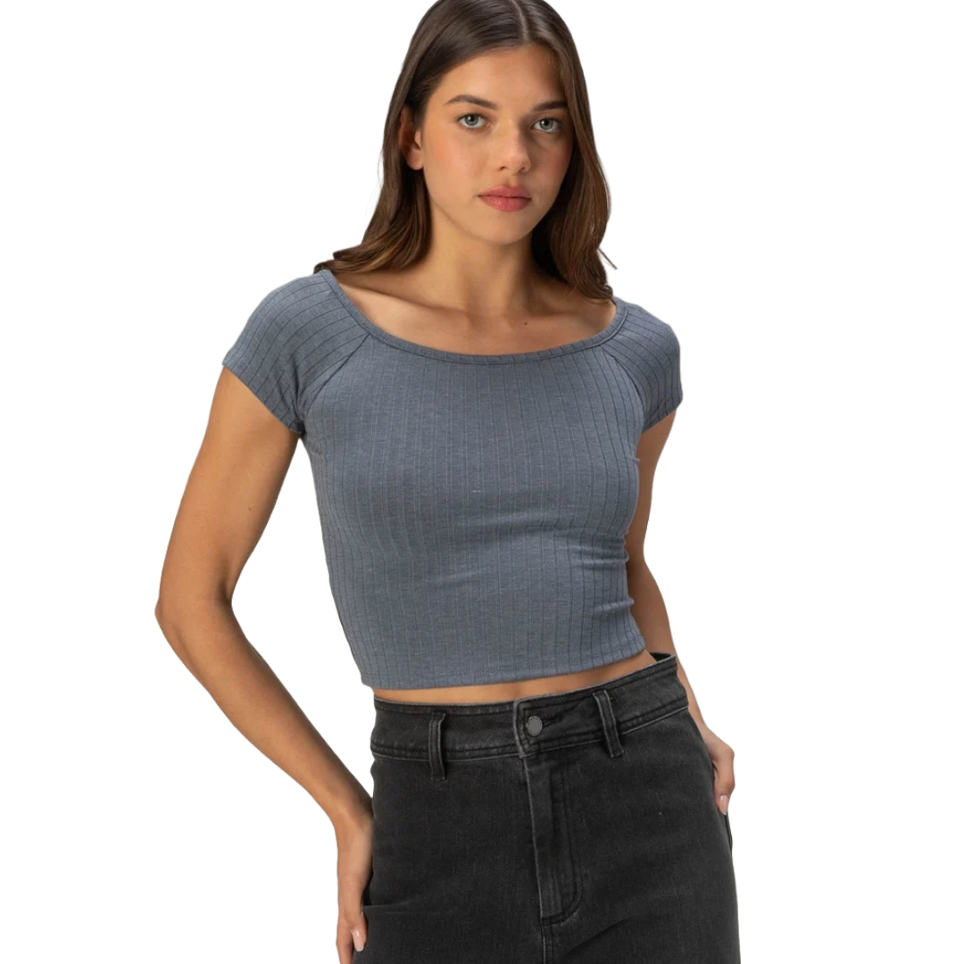 A woman wearing a ribbed, short-sleeve, gray crop top paired with high-waisted black jeans.