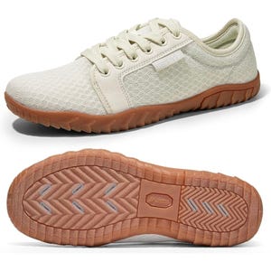 A beige lace-up casual shoe with a textured upper and a brown rubber sole, featuring a tread pattern for traction.