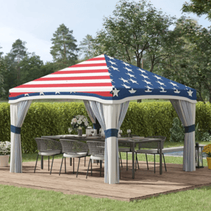 A patio canopy with an American flag design covers an outdoor dining set, featuring a wooden deck, chairs, and a table.