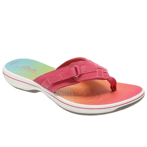 A pink thong sandal with a rainbow-colored footbed and white sole, featuring stitching and buckle details.