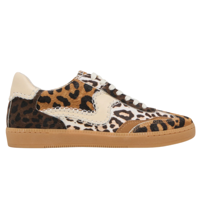 A sneaker featuring a multicolored animal print design with black, brown, and beige fur textures, complete with a gum-colored sole and white laces.