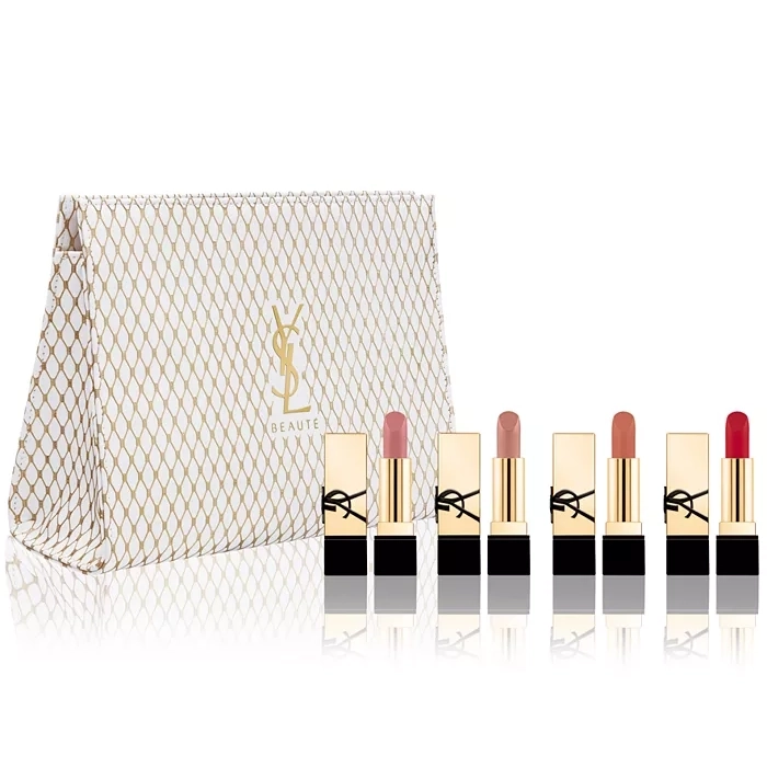 A collection of five lipsticks in various shades from pale pink to bold red, alongside a gold and white patterned cosmetics bag with a YSL logo.