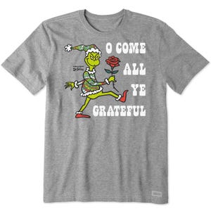 Gray T-shirt featuring a character in a festive outfit holding a rose, with the text \“O Come All Ye Grateful.\“ Collaboration with Dr. Seuss and \“Life is Good.\“