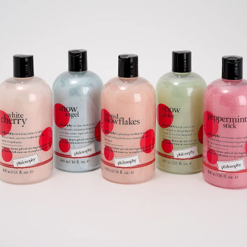 five multicolored shower gels on a grey background
