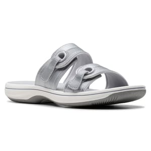 A silver slip-on sandal with two thick straps featuring circular cutout details, a slightly elevated white sole, and a textured grip bottom.